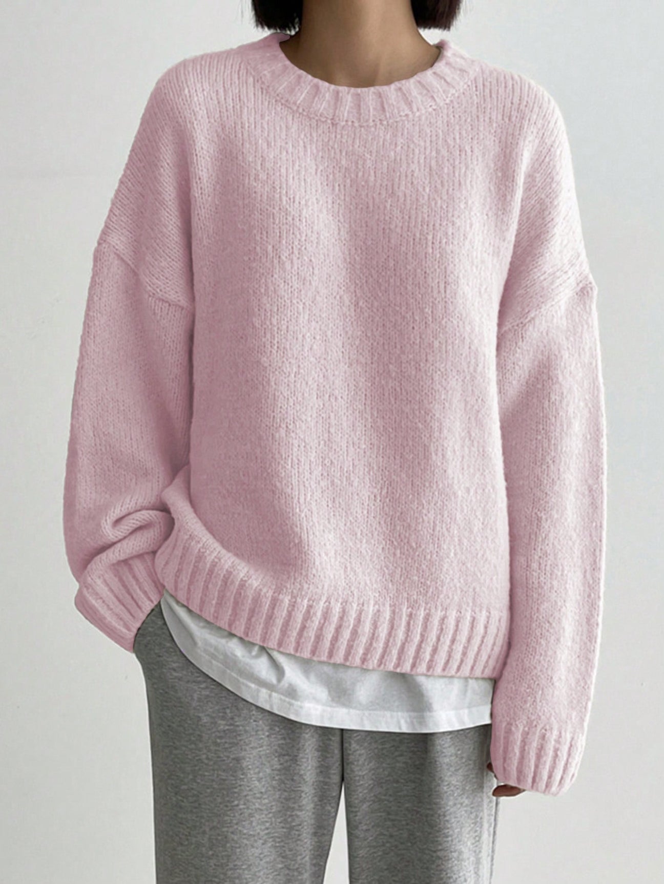 Pink solid color sweater with long sleeves and round neck